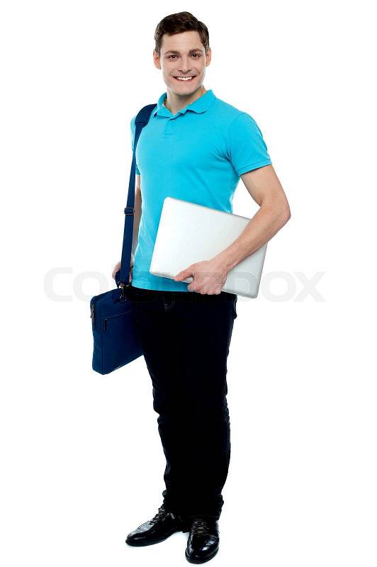 Cheerful man carrying laptop, off to work | Stock Photo | Colourbox